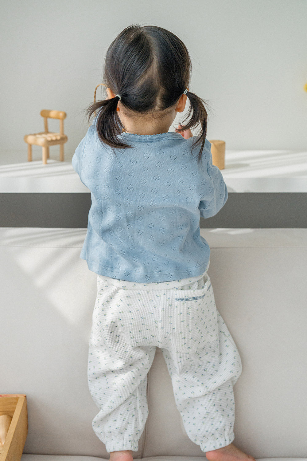 Back view of toddler in Avauma Skybloom knit baby cardigan with heart pattern, lightweight and breathable Back view of toddler in Avauma Skybloom knit baby cardigan with heart pattern, lightweight and breathable