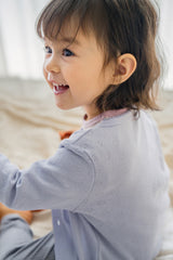 Back view of toddler in Avauma Haze Heart Cardigan, cozy and stylish lavender baby cardigan with delicate knit texture. Back view of toddler in Avauma Haze Heart Cardigan, cozy and stylish lavender baby cardigan with delicate knit texture.