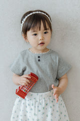 Toddler Holding a Toy Book in Avauma Le Petite Soft Gray Short Sleeve Knit Top and Eyelet Skirt
Toddler Holding a Toy Book in Avauma Le Petite Soft Gray Short Sleeve Knit Top and Eyelet Skirt