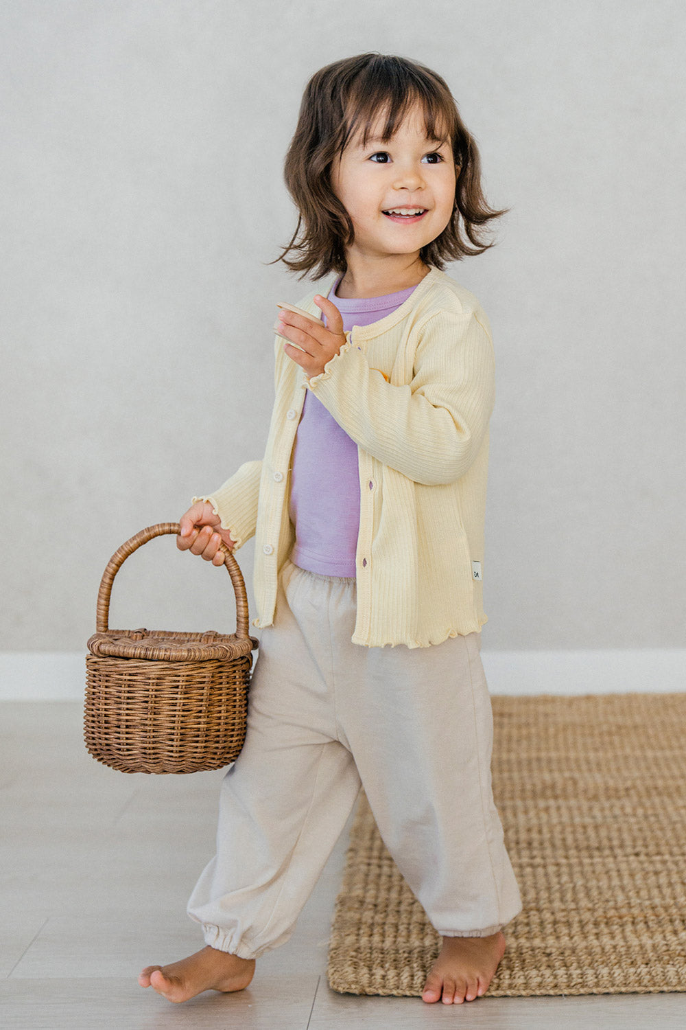 Toddler wearing Avauma Lavender Pale jogger set layered with yellow cardigan – comfy layered baby look
 Toddler wearing Avauma Lavender Pale jogger set layered with yellow cardigan – comfy layered baby look