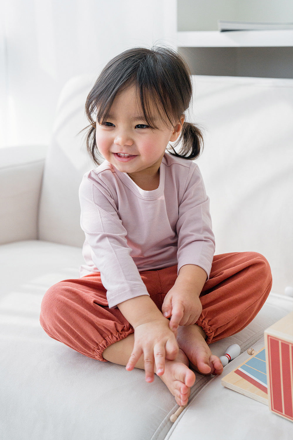 Toddler girl smiling in Avauma Rosy Cocoa jogger set – soft cotton loungewear for baby girls
 Toddler girl smiling in Avauma Rosy Cocoa jogger set – soft cotton loungewear for baby girls