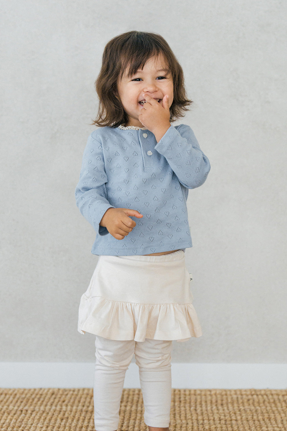 Smiling toddler wearing Avauma Lovely Breeze Henley Shirt in Haze Sky – Comfortable babywear for all-day play Smiling toddler wearing Avauma Lovely Breeze Henley Shirt in Haze Sky – Comfortable babywear for all-day play