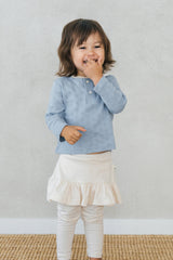 Smiling toddler wearing Avauma Lovely Breeze Henley Shirt in Haze Sky – Comfortable babywear for all-day play Smiling toddler wearing Avauma Lovely Breeze Henley Shirt in Haze Sky – Comfortable babywear for all-day play