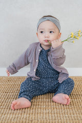 Baby girl in Avauma Ocean Fleur pajama layered with a cardigan – cozy floral baby outfit
 Baby girl in Avauma Ocean Fleur pajama layered with a cardigan – cozy floral baby outfit