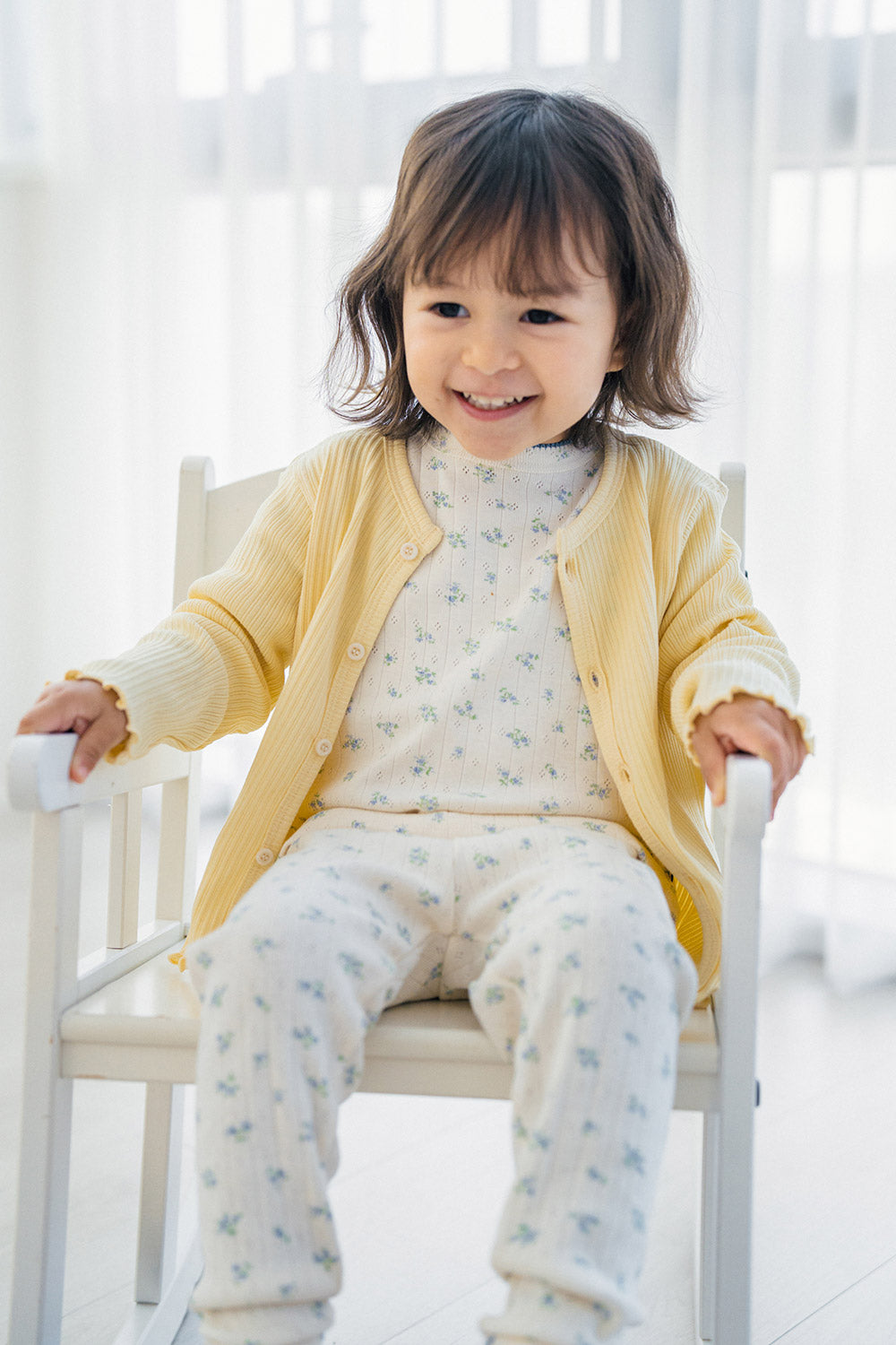 Toddler girl wearing Avauma Sky Blossom pajama with yellow cardigan – soft layered baby outfit
 Toddler girl wearing Avauma Sky Blossom pajama with yellow cardigan – soft layered baby outfit