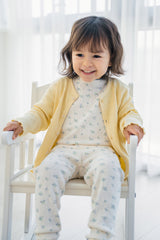 Toddler girl wearing Avauma Sky Blossom pajama with yellow cardigan – soft layered baby outfit
 Toddler girl wearing Avauma Sky Blossom pajama with yellow cardigan – soft layered baby outfit