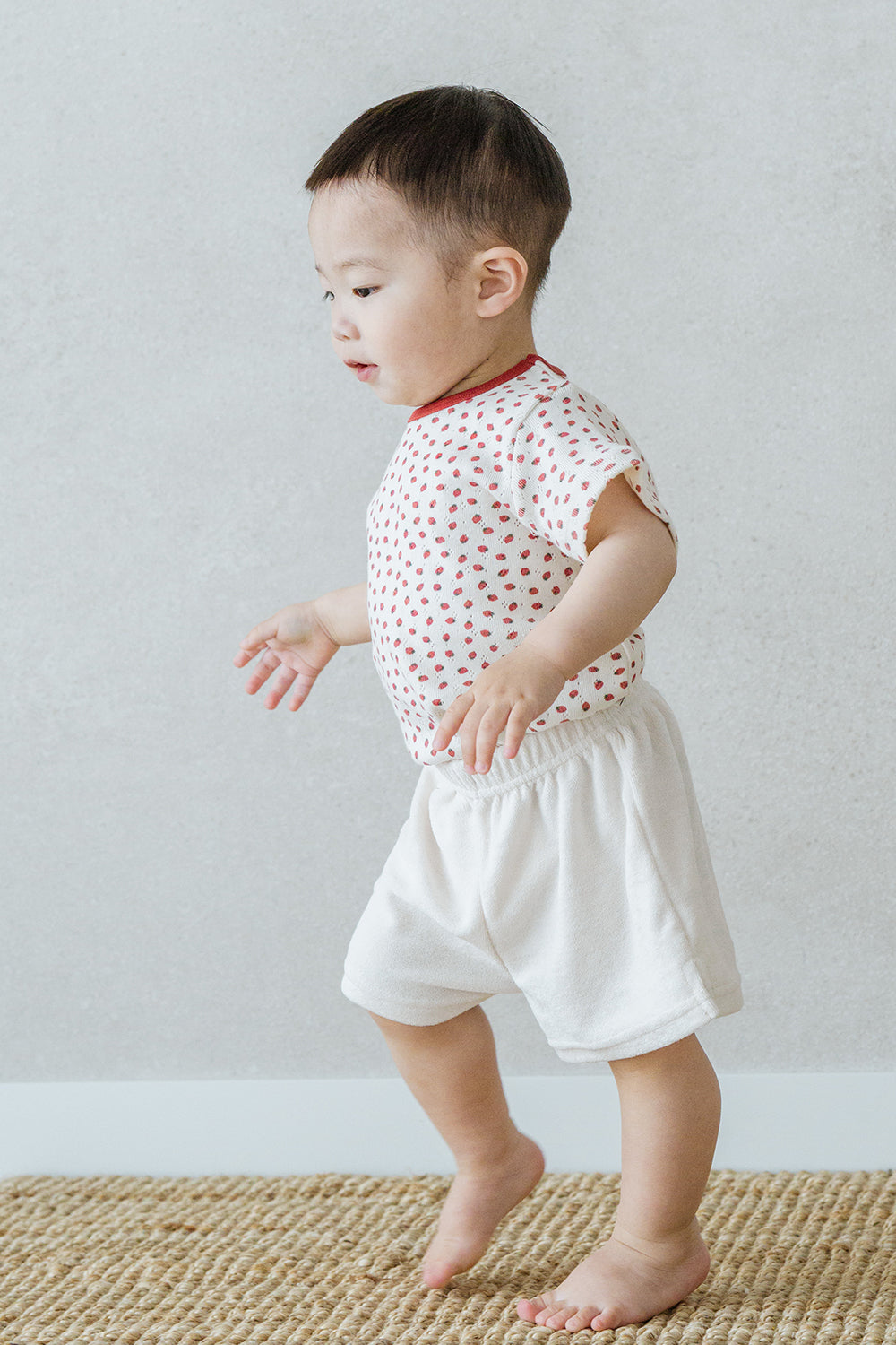 Toddler boy walking indoors wearing comfortable Avauma Mellow Pop Ivory Berry clothing set Toddler boy walking indoors wearing comfortable Avauma Mellow Pop Ivory Berry clothing set