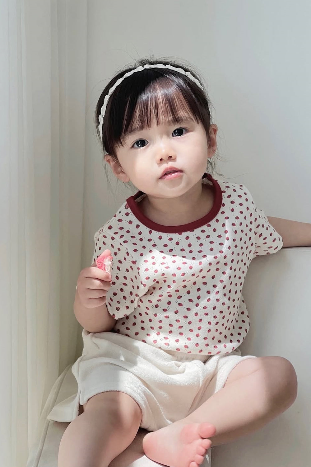 Cute toddler girl looking directly at camera, wearing Avauma Ivory Berry T-Shirt and Shorts Cute toddler girl looking directly at camera, wearing Avauma Ivory Berry T-Shirt and Shorts