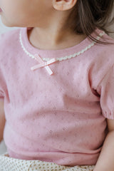 Close-up of Avauma Merry Purp Cotton Pink Top with Delicate Ribbon Detail, Soft Baby Girl Fashion
Close-up of Avauma Merry Purp Cotton Pink Top with Delicate Ribbon Detail, Soft Baby Girl Fashion