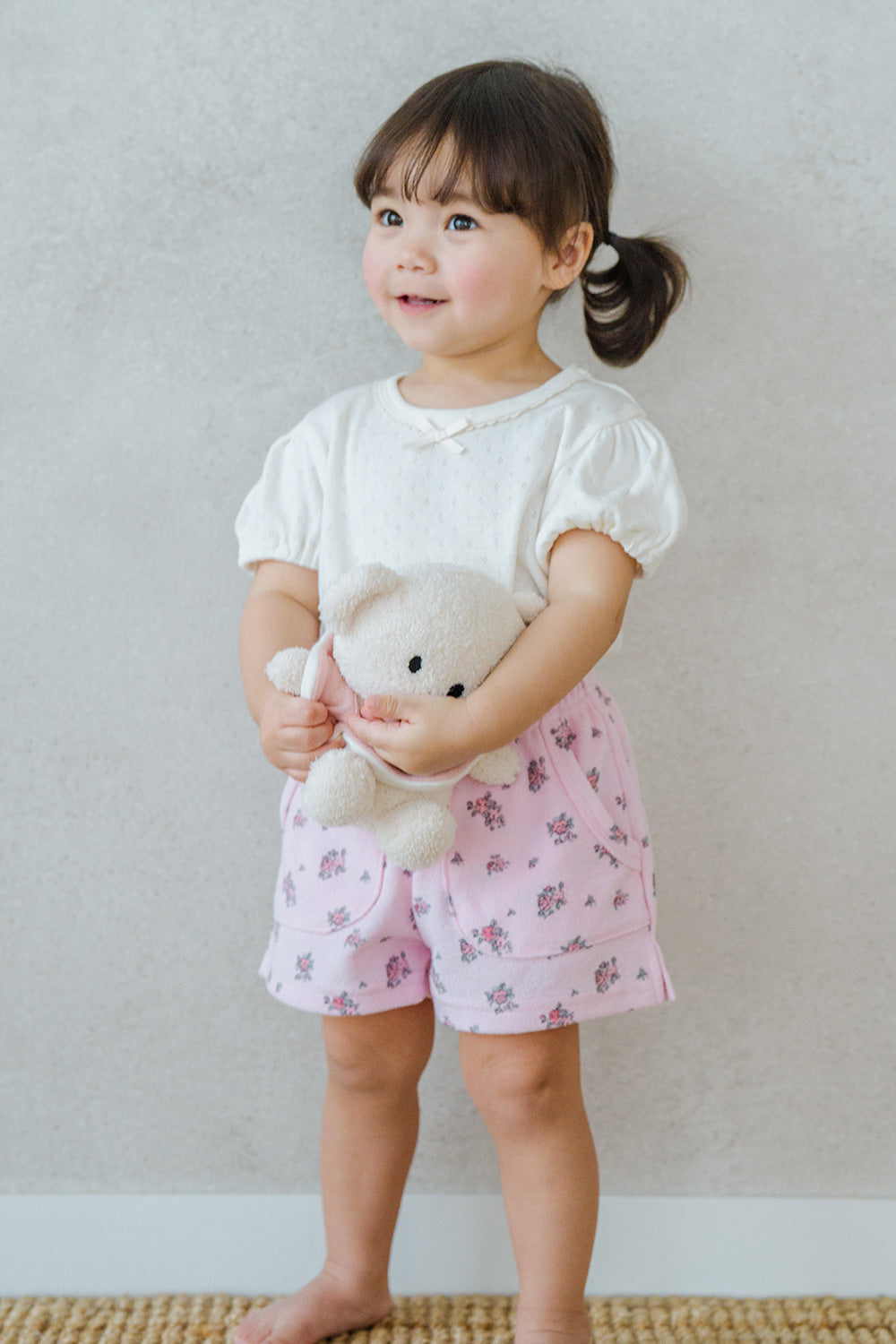 Standing Toddler Wearing Avauma Merry Purp Vanilla Cream Puff Sleeve T-Shirt, Matched with Pink Shorts
Standing Toddler Wearing Avauma Merry Purp Vanilla Cream Puff Sleeve T-Shirt, Matched with Pink Shorts