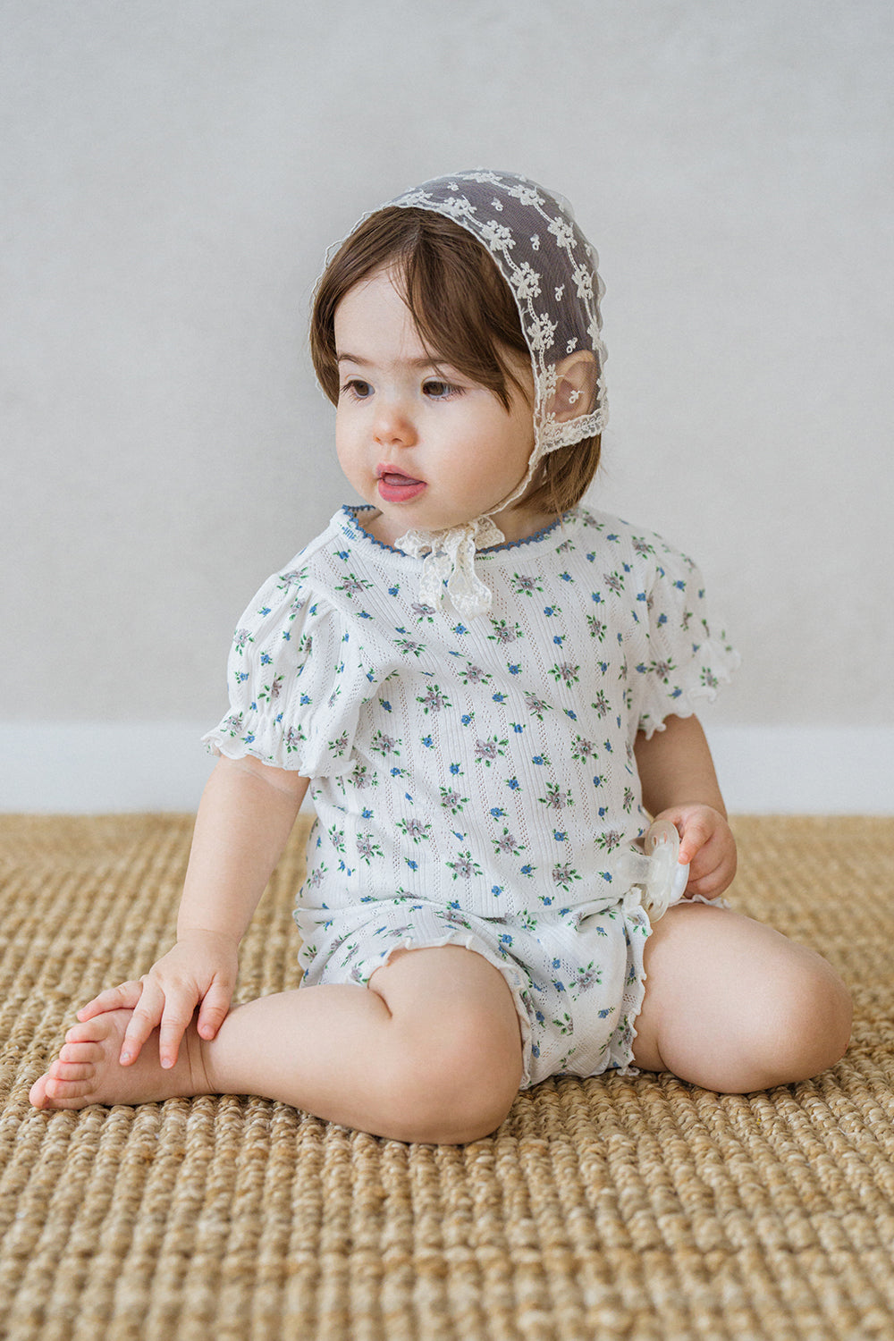 Baby girl wearing Avauma Petit Ruffle Bluebell short sleeve set, sitting on a beige carpet.
Baby girl wearing Avauma Petit Ruffle Bluebell short sleeve set, sitting on a beige carpet.