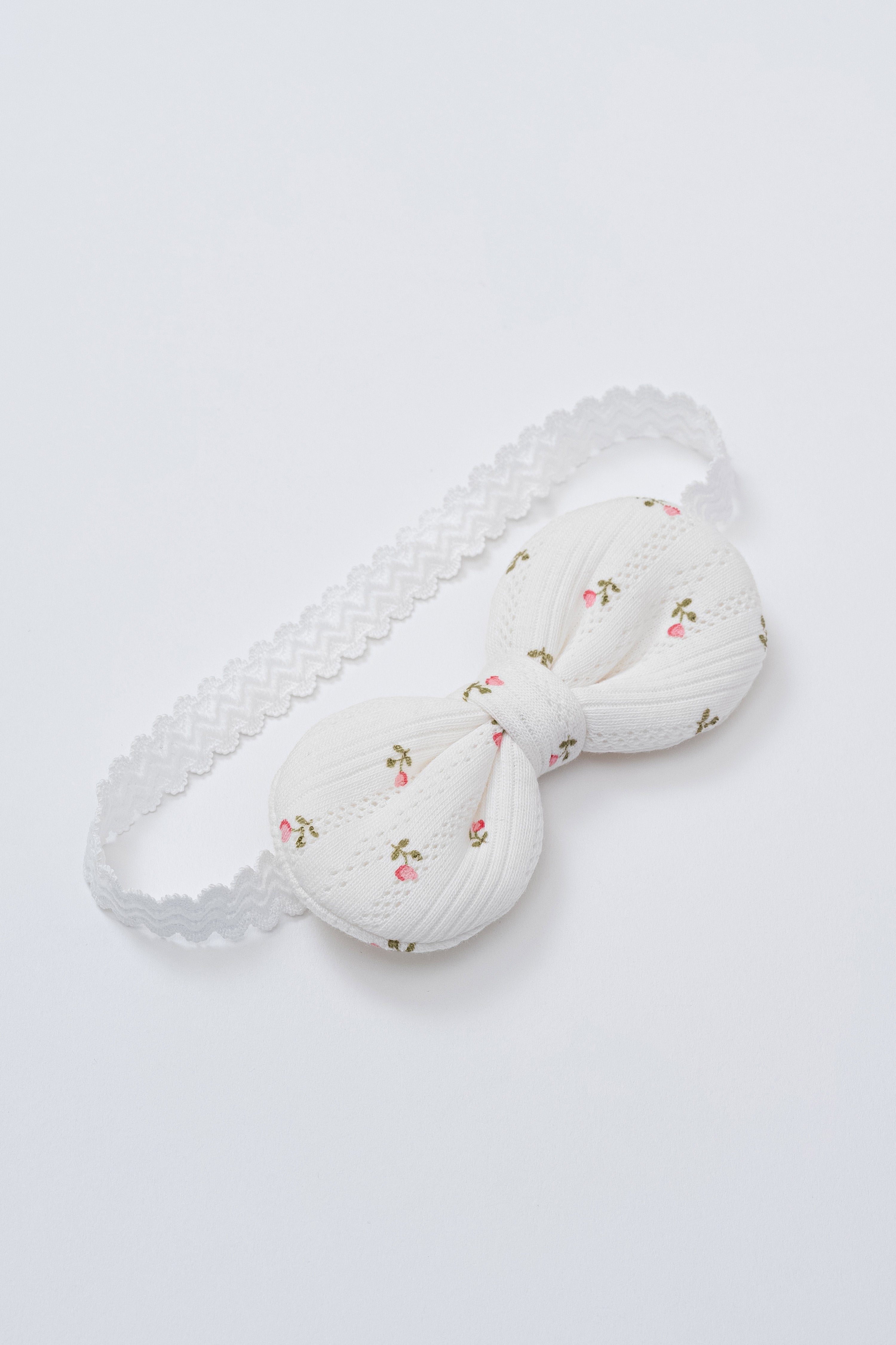 Avauma Petite Garden Baby Headband in Rose Garden with pink rosebud print on white textured cotton and soft elastic band Avauma Petite Garden Baby Headband in Rose Garden with pink rosebud print on white textured cotton and soft elastic band