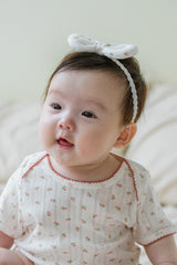 Baby girl sitting up wearing Avauma Petite Garden Headband in Rose Garden, paired with matching floral outfit Baby girl sitting up wearing Avauma Petite Garden Headband in Rose Garden, paired with matching floral outfit