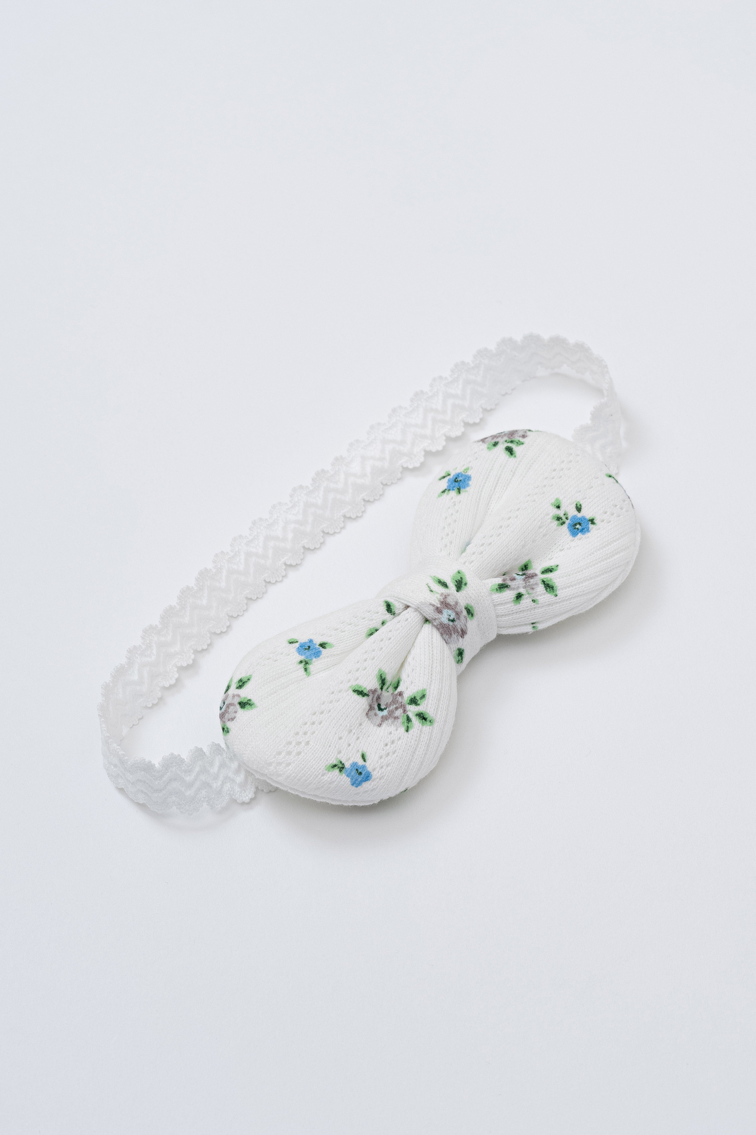 Avauma Petite Garden Baby Headband in Sky Garden, featuring soft white cotton with blue floral embroidery and elastic lace band Avauma Petite Garden Baby Headband in Sky Garden, featuring soft white cotton with blue floral embroidery and elastic lace band