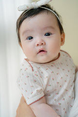 Close-up of Baby in Avauma Petite Garden Rosegarden Short Sleeve Bodysuit, Puff Sleeve with Delicate Trim
Close-up of Baby in Avauma Petite Garden Rosegarden Short Sleeve Bodysuit, Puff Sleeve with Delicate Trim