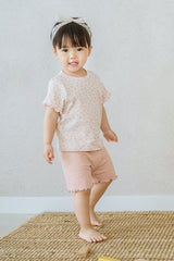 Toddler girl standing on rug in rosy blush Pure Hug baby summer set, pink ribbed shorts and floral top, playful expression.
Toddler girl standing on rug in rosy blush Pure Hug baby summer set, pink ribbed shorts and floral top, playful expression.