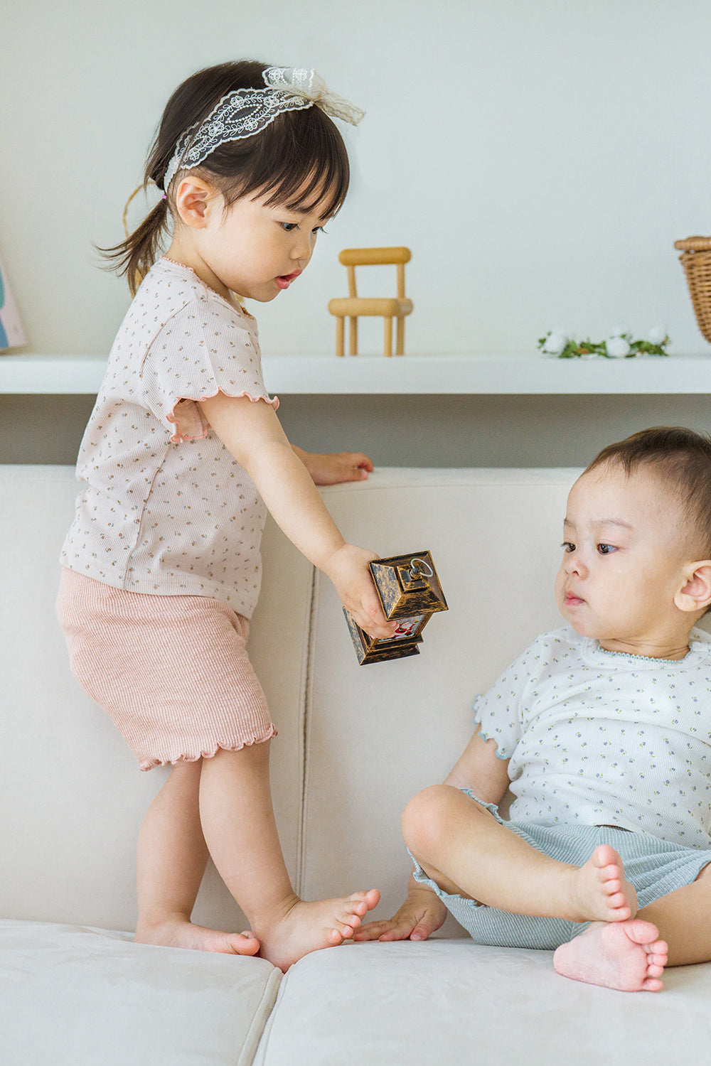 Toddler girl sharing toy with baby boy, both in Pure Hug summer sets, girl in rosy blush, boy in vanilla mint. - Avauma Toddler girl sharing toy with baby boy, both in Pure Hug summer sets, girl in rosy blush, boy in vanilla mint. - Avauma