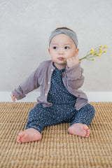 Avauma ribbed baby cardigan in Ash Beige, soft cotton sweater layered over floral jumpsuit for infants Avauma ribbed baby cardigan in Ash Beige, soft cotton sweater layered over floral jumpsuit for infants