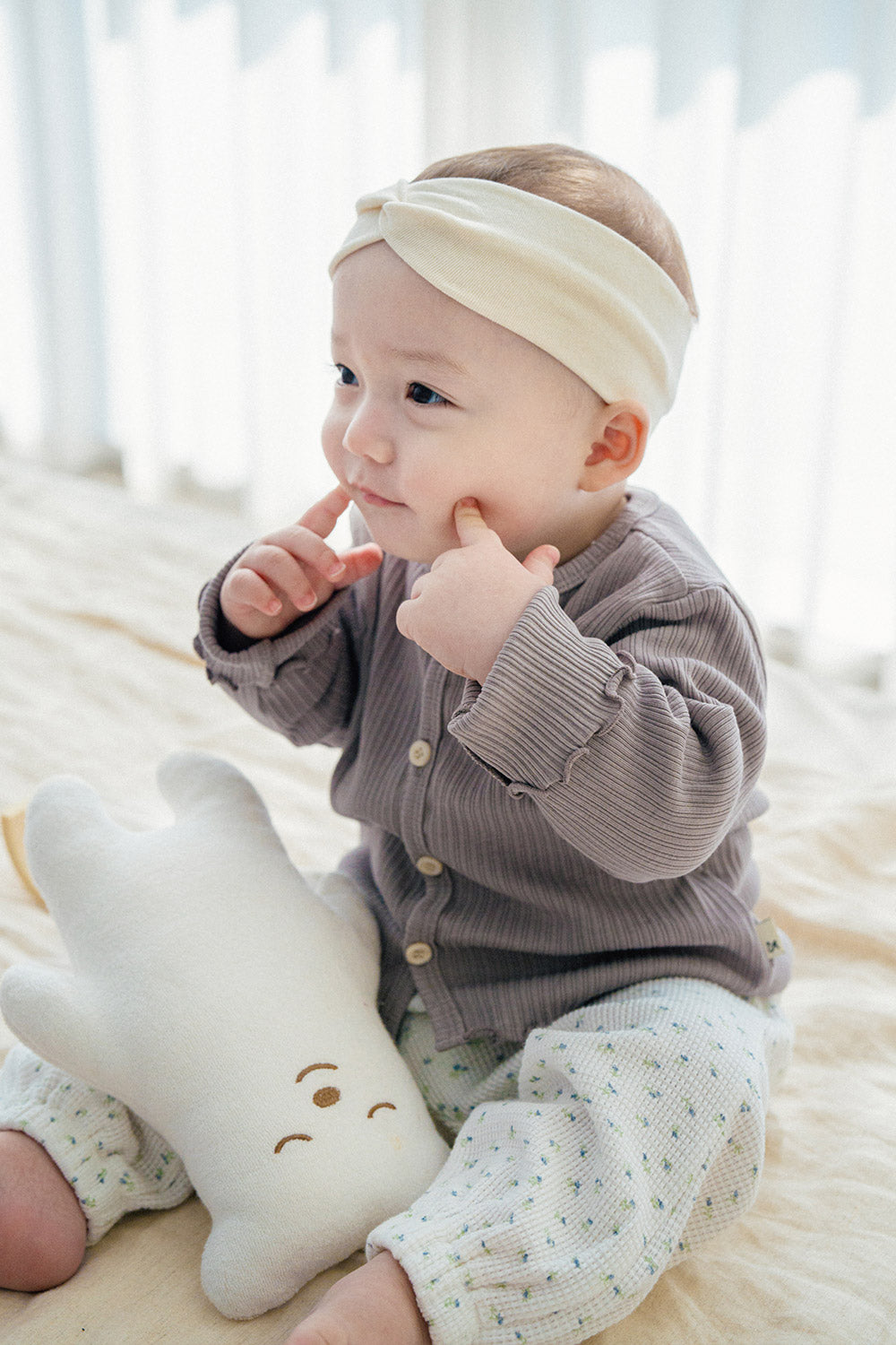 Baby wearing Avauma Ash Beige ribbed cardigan with floral baby pants, cozy infant outfit with headband Baby wearing Avauma Ash Beige ribbed cardigan with floral baby pants, cozy infant outfit with headband