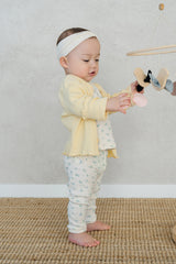Infant girl in Avauma butter yellow cardigan and floral baby pants, cozy and cute baby outfit for playtime Infant girl in Avauma butter yellow cardigan and floral baby pants, cozy and cute baby outfit for playtime