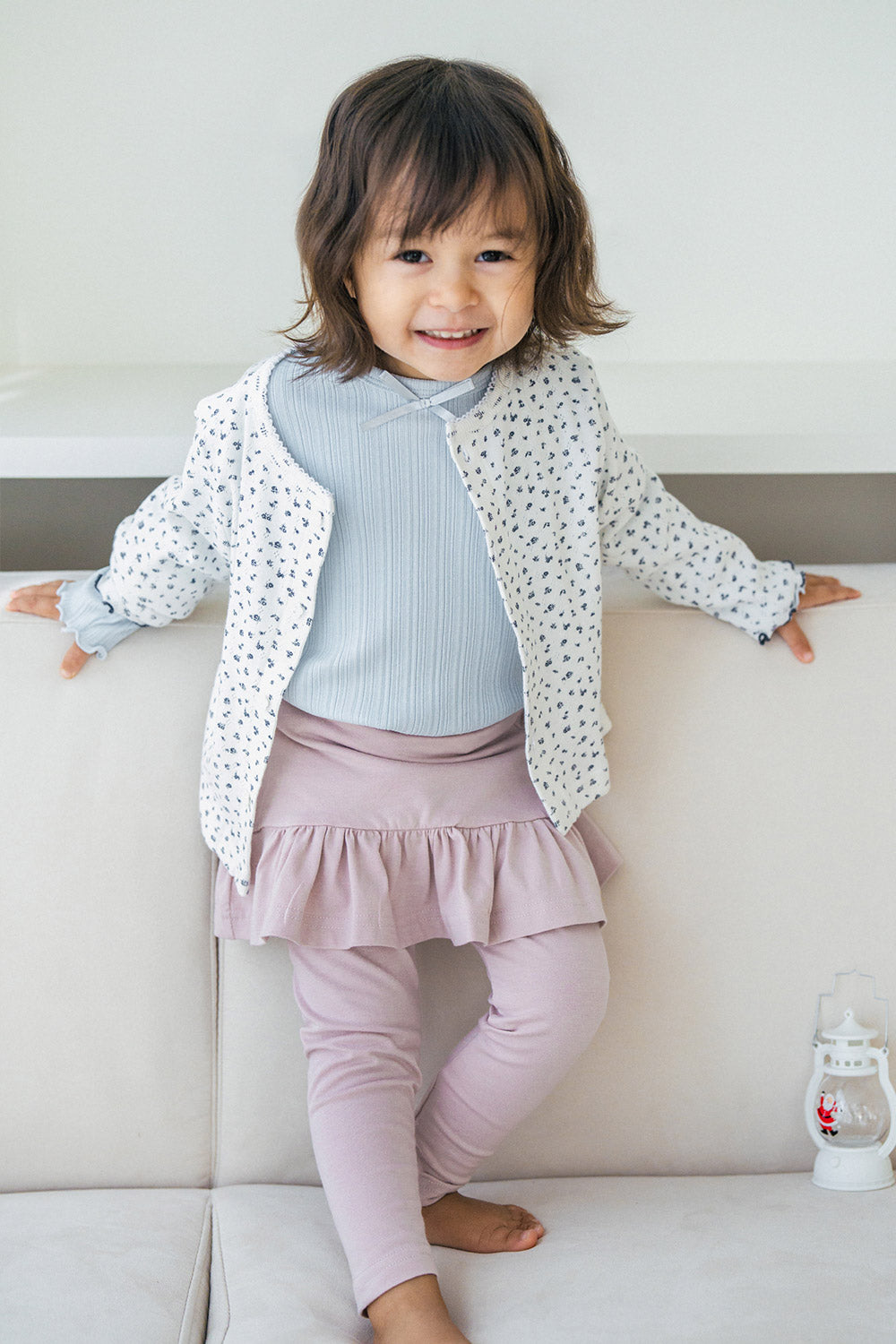 Smiling toddler girl wearing Avauma baby skirt leggings in powder pink and floral cardigan โ cute spring outfit Smiling toddler girl wearing Avauma baby skirt leggings in powder pink and floral cardigan โ cute spring outfit