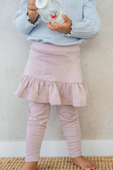 Baby girl holding toy while wearing Avauma powder pink ruffled skirt leggings โ soft and stretchy leggings Baby girl holding toy while wearing Avauma powder pink ruffled skirt leggings โ soft and stretchy leggings