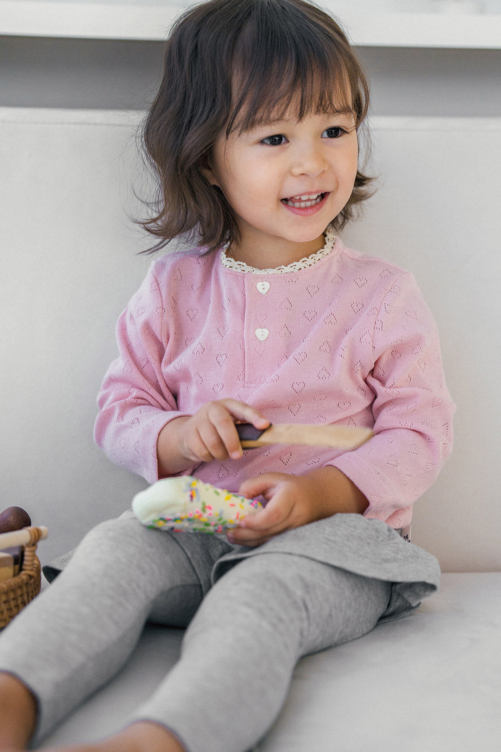 Toddler sitting with legs crossed, wearing Avauma silver misk baby skirt leggings and pink top โ everyday comfy outfit Toddler sitting with legs crossed, wearing Avauma silver misk baby skirt leggings and pink top โ everyday comfy outfit