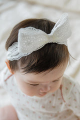 Top view of baby’s head wearing Avauma Cotton Cream Rumiere Ribbon Band, showing embroidery detail Top view of baby’s head wearing Avauma Cotton Cream Rumiere Ribbon Band, showing embroidery detail
