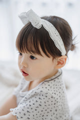 Side profile of toddler girl wearing Avauma Rumiere Ribbon Band - Cotton Cream with dotted ivory top Side profile of toddler girl wearing Avauma Rumiere Ribbon Band - Cotton Cream with dotted ivory top