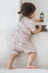Flat lay of Avauma Sienna Rose Rosy Powder short sleeve summer set, featuring a light pink color with small floral prints and ruffle trim. Flat lay of Avauma Sienna Rose Rosy Powder short sleeve summer set, featuring a light pink color with small floral prints and ruffle trim.
