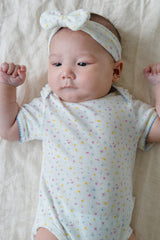 Close-up of Avauma Soft Rose Butter Garden Short Sleeve Bodysuit, Colorful Floral Dot Pattern on Ribbed Fabric
Close-up of Avauma Soft Rose Butter Garden Short Sleeve Bodysuit, Colorful Floral Dot Pattern on Ribbed Fabric