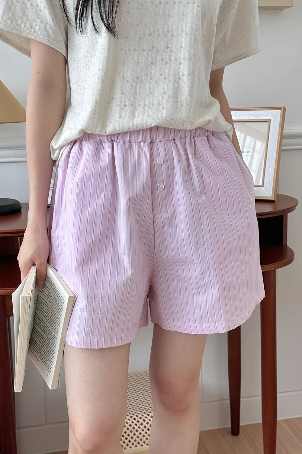 Model standing in Avauma Sunny Stripe lotus pink mom pants, holding a book.
Model standing in Avauma Sunny Stripe lotus pink mom pants, holding a book.