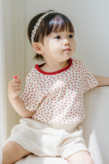 Baby girl in polka dot top wearing Avauma White Garden Band headband in Cream Beige, sitting by the window" Baby girl in polka dot top wearing Avauma White Garden Band headband in Cream Beige, sitting by the window"