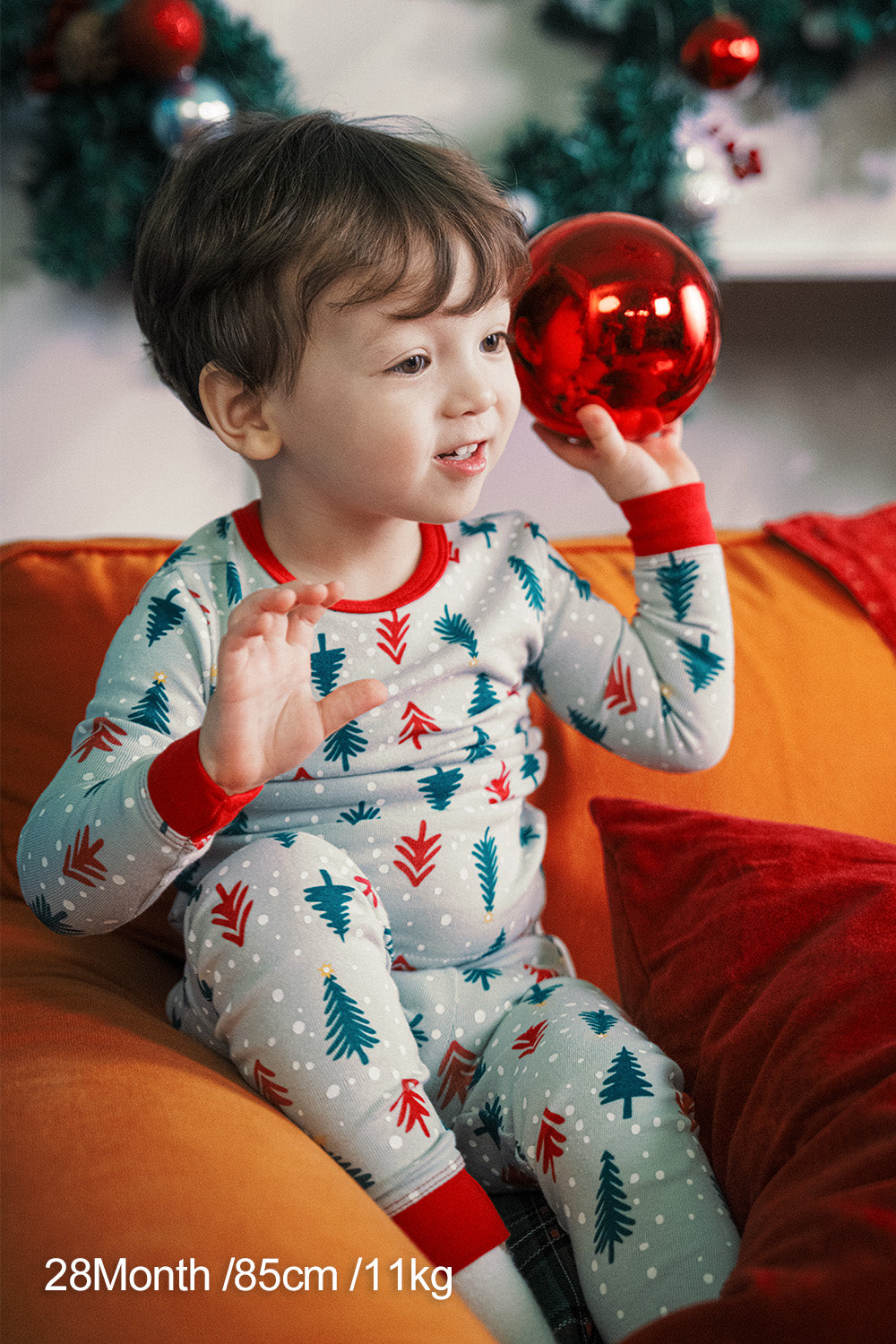 Baby surrounded by Christmas decorations, wearing AVAUMA Holiday Long Sleeve Pajama Set - Happy Tree