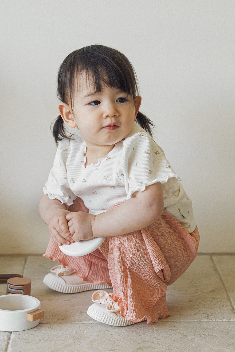 Toddler girl sitting in Avauma Rosevale pleated wide-leg pants