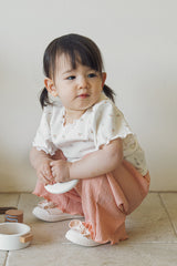 Toddler girl sitting in Avauma Rosevale pleated wide-leg pants