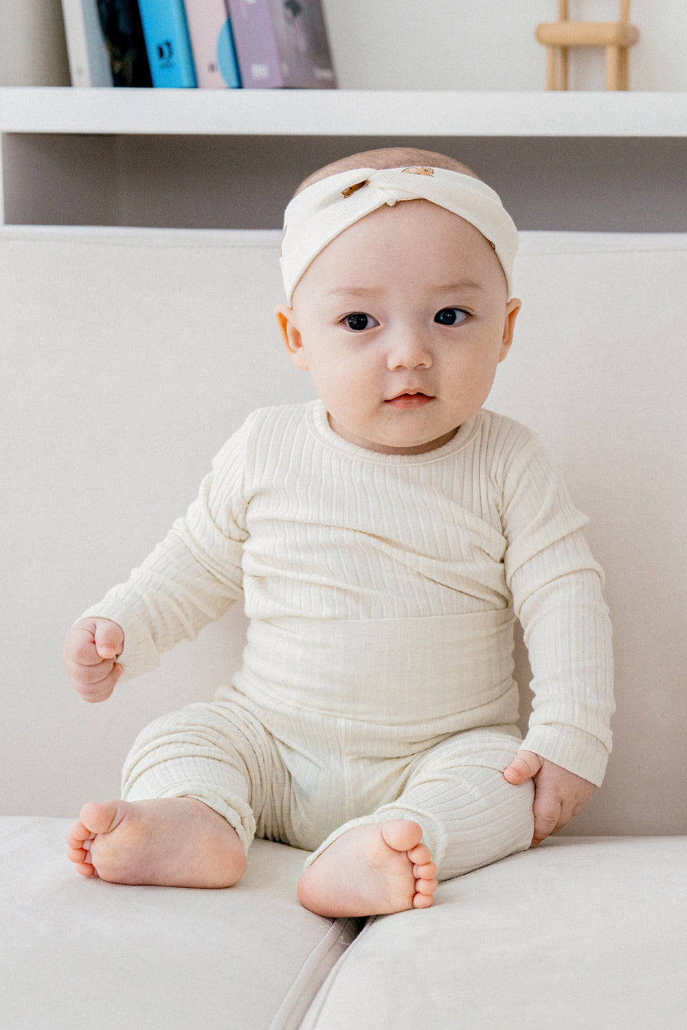 Baby wearing Avauma Pogny Long Sleeve Set in Cheese Cake color, soft cotton pajamas, comfortable sleepwear for newborn and infant, with a cute headband