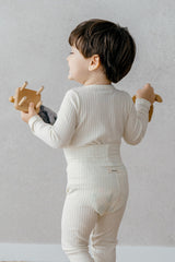 Toddler wearing Avauma Pogny Long Sleeve Set in Cheese Cake color, playing with toys in cozy ribbed pajamas, perfect sleepwear for day and night