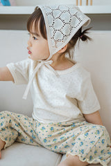 Side view of toddler girl in Avauma milk pearl lace short sleeve tee and heart lace bonnet


