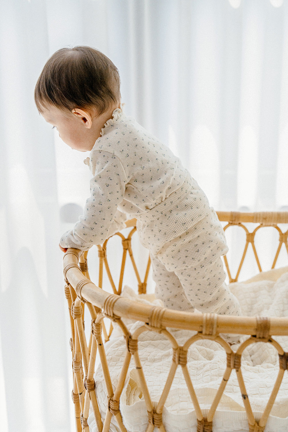 Toddler playing in Avauma Eyelet Bloom Setup Pajamas - Creamy Flower, capturing the cozy and adorable look of the cream-colored floral top and bottom pajama set for babies.