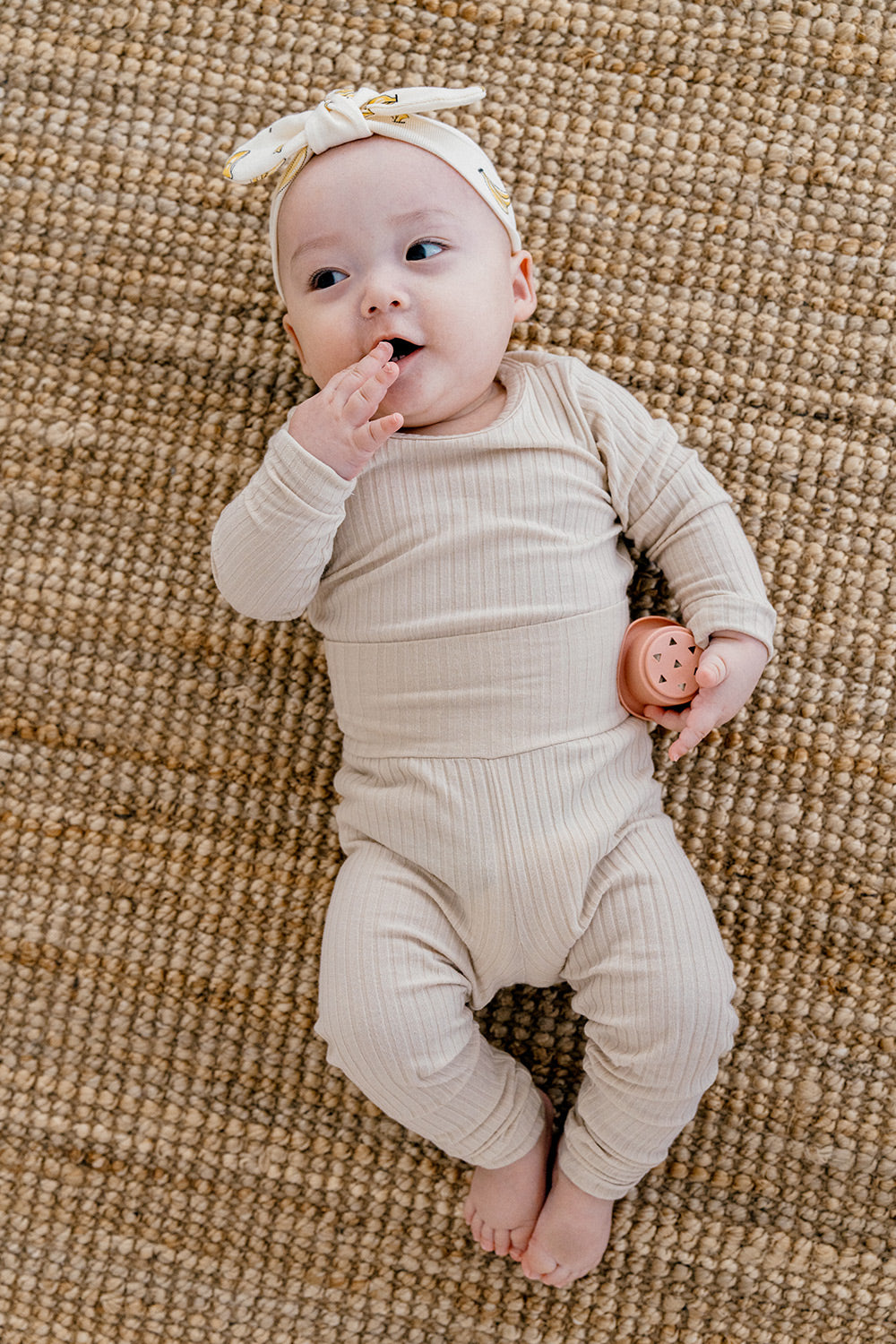 Toddler playing in soft ribbed baby pajamas set in Crimson Caramel by Avauma, cozy sleepwear for boys and girls, ideal for day and night