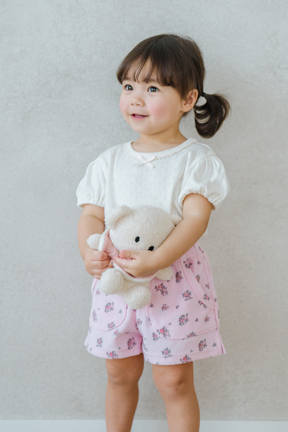 Smiling Toddler in Avauma Fluffy Garden Peach Mood Shorts, Pink Floral Cotton Baby Shorts for Daily Wear

