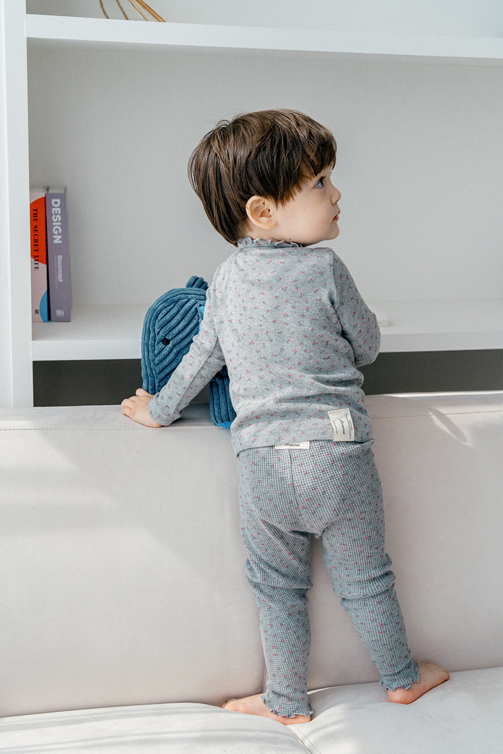 Toddler standing in Avauma Eyelet Bloom Setup - Gray Bloom, featuring a stylish and comfortable gray pajama set with floral details.