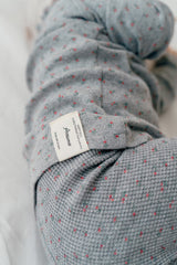 Back view of a baby in Avauma Eyelet Bloom Setup - Gray Bloom, highlighting the soft fabric and floral print of the gray pajama set.