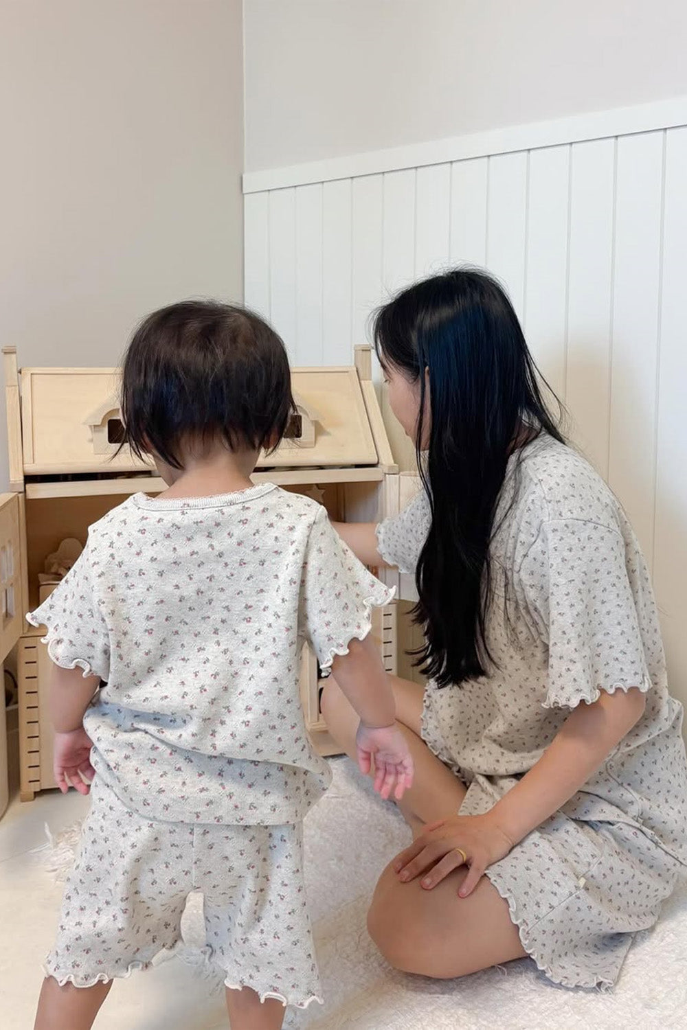 Back view of mom and baby in AVAUMA matching Berry Cream pajamas playing together

