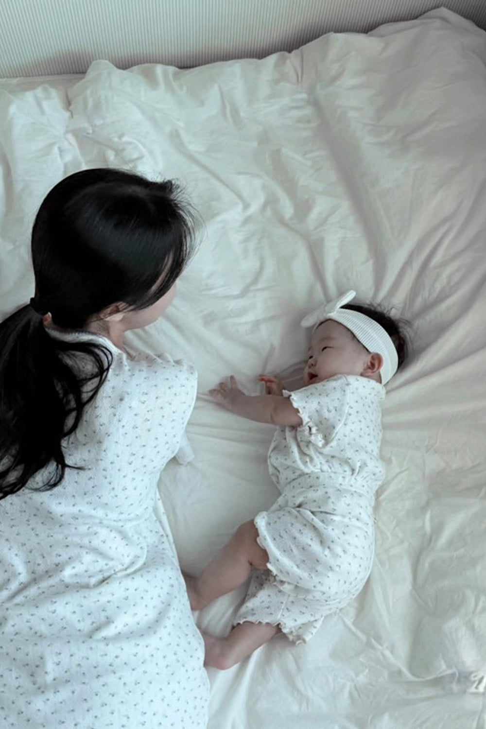AVAUMA mom and baby lying on bed in vanilla herb floral matching pajamas
