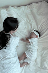AVAUMA mom and baby lying on bed in vanilla herb floral matching pajamas