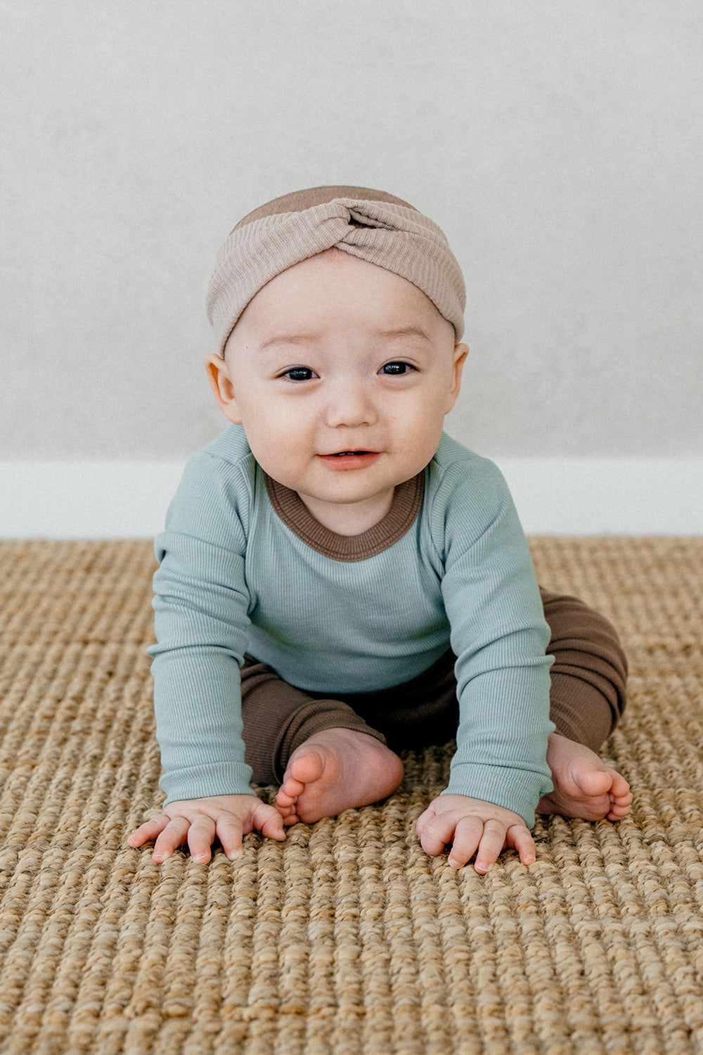 Baby crawling in Avauma's Coco Classic Long Sleeve Set in Applemint bun color - soft green and brown two-piece baby pajamas for cozy, all-day comfort, ideal as sleepwear.