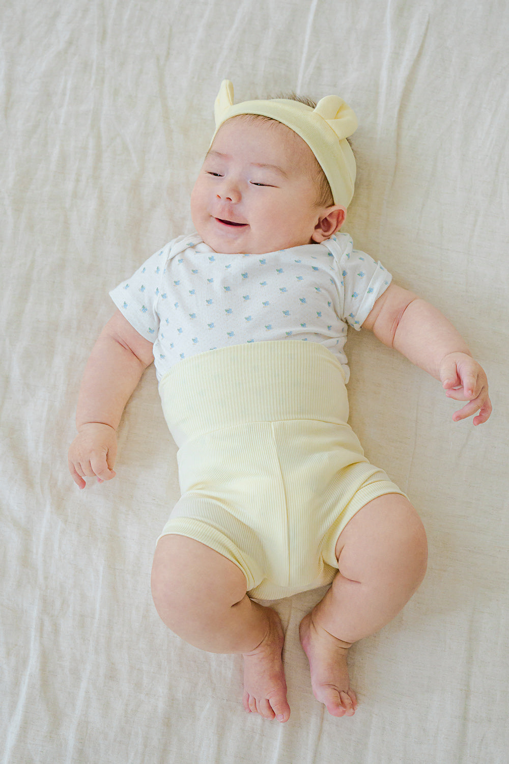 Newborn baby in Avauma Baby Hug Setup Peach Blossom. Infant model comfortably lying down, showcasing soft pink baby outfit.
