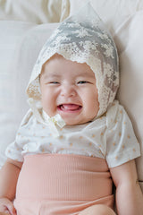 Newborn baby in Avauma Baby Hug Setup Peach Blossom. Infant model comfortably lying down, showcasing soft pink baby outfit.